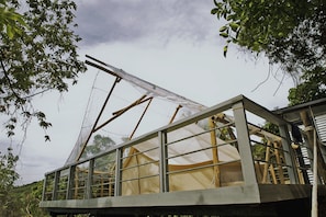 A wooden structure with a transparent roof, surrounded by trees. - The Birdhouse El Nido - Glamping (El Nido)