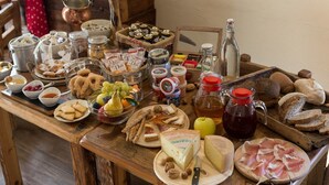 A wooden table with various food items including cheese, bread, and condiments. - La Maison d'Antan (Bionaz)