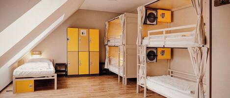 Un dormitorio con literas, un escritorio, una silla y un armario.