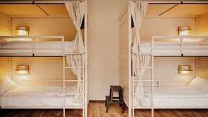 Una habitación con dos literas, cada una con una escalera y un taburete pequeño. Hay luces fijadas en la pared sobre cada cama.