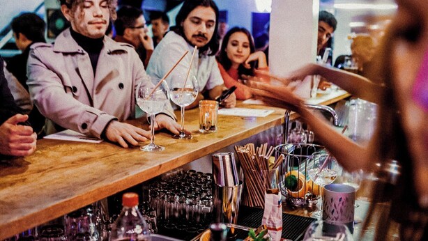 A bar area with a wooden counter, glasses, and bottles. - Wombat's City Hostel Vienna Naschmarkt (Vienna)