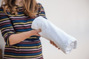 A person holding a rolled white towel.
