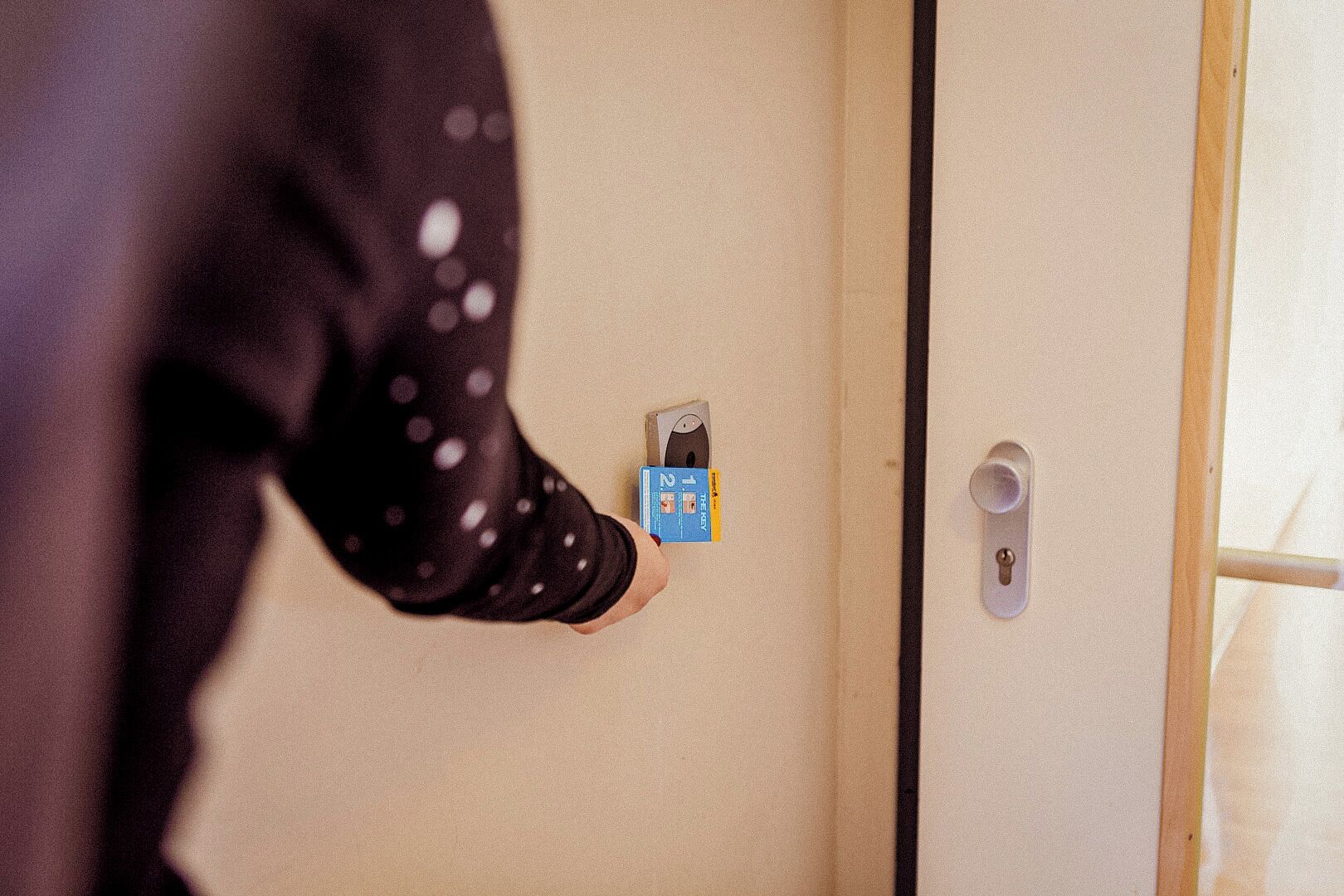 Una persona abriendo una puerta con una tarjeta de acceso.