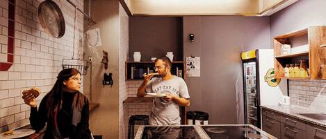 Uma cozinha moderna com uma ilha central, micro-ondas e geladeira.