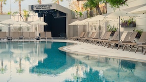 A swimming pool with lounge chairs and umbrellas, a stage, and a sign for 'KLEOPATRA DREAMS BEACH HOTEL'. - Kleopatra Dreams Beach Hotel (Alanya)