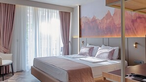 Een moderne hotelkamer met een groot bed, een bureau en een stoel.
