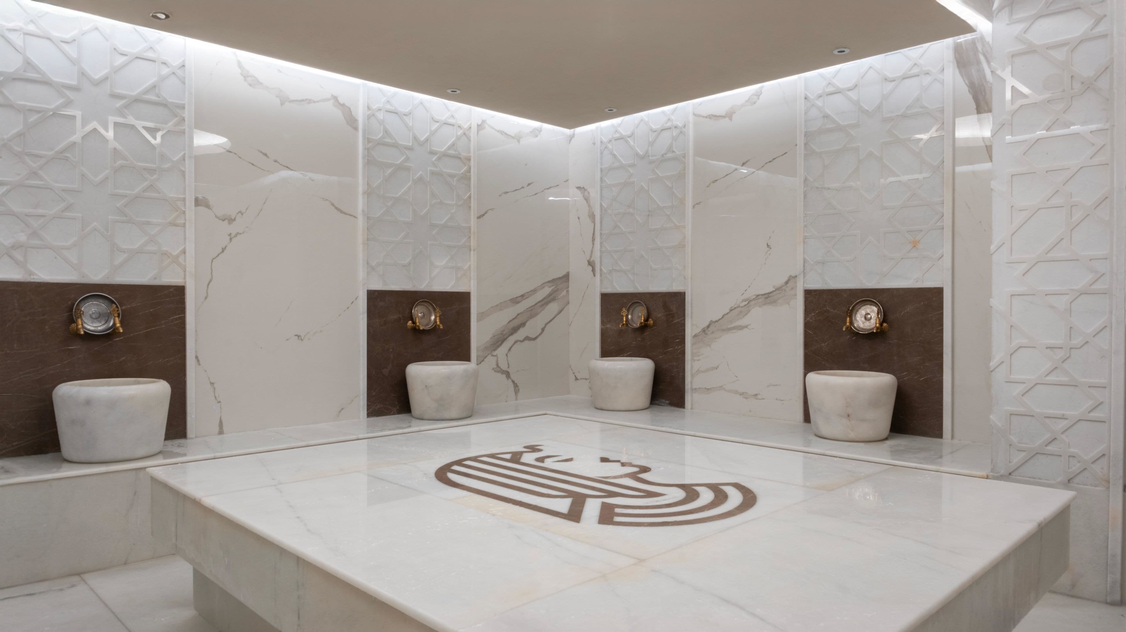 A modern bathroom with marble walls, a central sink, and decorative wall panels.