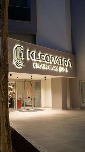 The exterior of the Cleopatra Dreams Beach Hotel with a prominent illuminated sign.