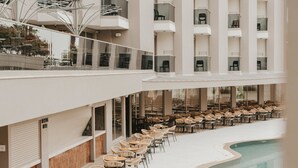 Een modern hotel met een zwembad, meerdere verdiepingen en terras.