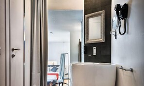 Un baño moderno con un lavamanos grande, un espejo y un teléfono.