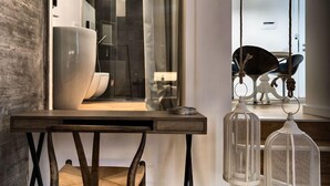 Un intérieur moderne avec une table en bois, une chaise et deux cages à oiseaux suspendues.