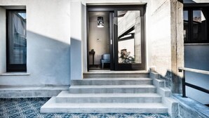 Une entrée moderne, avec un ensemble de marches en béton menant à une porte.