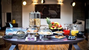 Un buffet de petit-déjeuner proposant une variété d’aliments, notamment des fruits, des viennoiseries et des boissons.