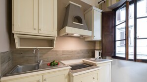 A kitchen with a sink, stove, and cabinets. - Flospirit - San Lorenzo (Florence)
