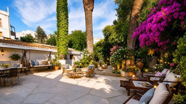 A patio with outdoor furniture, potted plants, and a stone floor. - Hotel Hieracon (Carloforte)