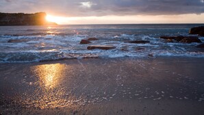 A beach with waves, rocks, and a sunset. - Hotel Hieracon (Carloforte)