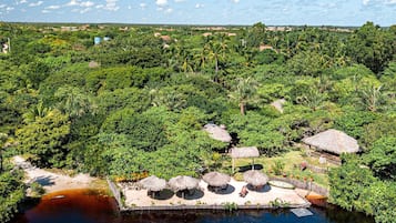 En la playa, sillas reclinables de playa, sombrillas, bar en la playa