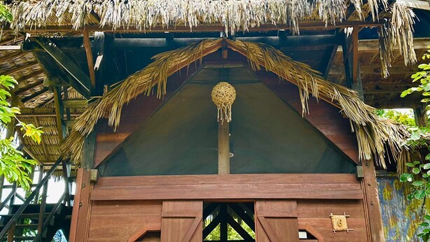 A wooden treehouse with a thatched roof, multiple levels, and a central hanging ornament. - Ciamat Camp (Santo Amaro do Maranhão)