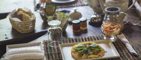 Uma mesa posta com um prato de comida, um bule de chá e diversos acompanhamentos.