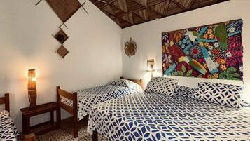 Una habitación con dos camas, piso estampado y techo de madera.