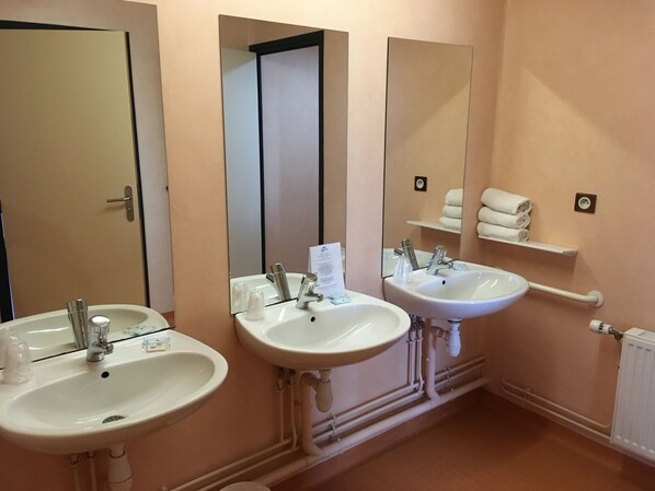 A bathroom with two sinks, a mirror, and a towel rack.