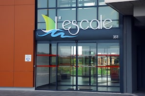 Un bâtiment doté d’une grande entrée en verre, d’une enseigne indiquant « L’école » et du numéro 351.