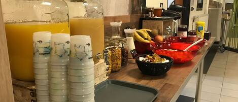 A breakfast buffet with orange juice, yogurt cups, and various food items.