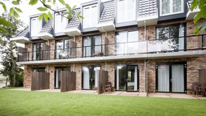 A modern two-story house with a flat roof, large windows, and a well-maintained lawn. - Van Heeckeren Hotel (Nes)