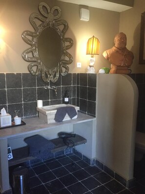 Un bagno con lavandino, specchio e oggetti decorativi.