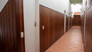Un pasillo con puertas de madera y suelo de baldosas.