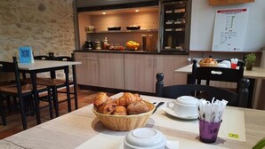 Desayuno con croissants, una cafetera y un letrero de menú.