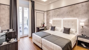 Ein modernes Hotelzimmer mit einem großen Bett, einem Schreibtisch und einer Sitzecke.