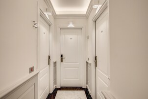 A narrow hallway with white walls and doors numbered 307 and 308.