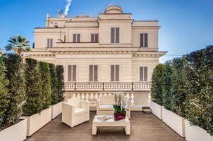 A large, two-story building with a balcony and outdoor seating area.