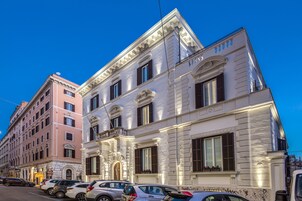 A multi-story building with classical architecture, featuring a balcony and large windows.