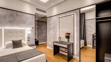 Quarto moderno com cama grande, mesa de cabeceira e espelho.