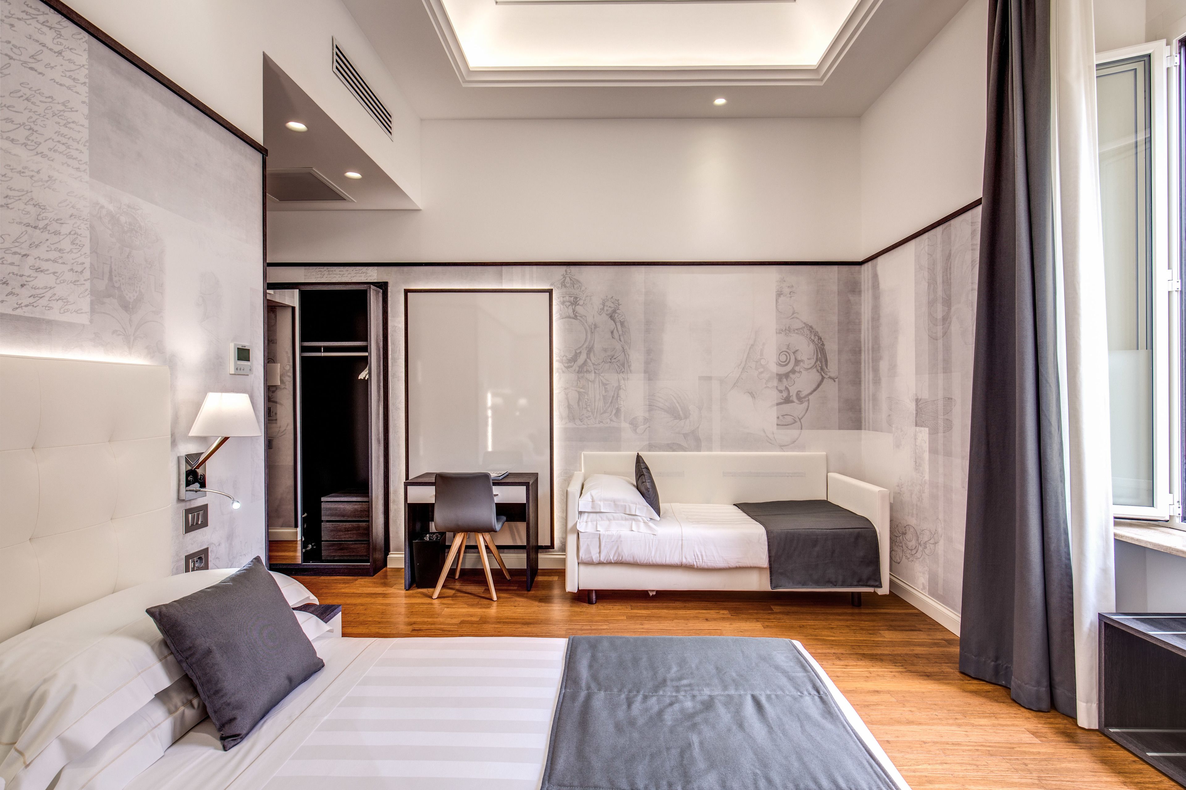 Una habitación de hotel moderna con una cama grande, un escritorio y una zona de estar.