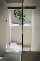 Una escalera con escalones de mármol que conduce a una plataforma con una planta en maceta.