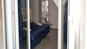 A bedroom with a bed, a nightstand, and a window with curtains.