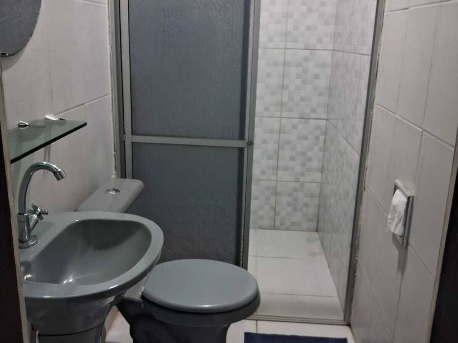 Un baño pequeño con lavamanos, inodoro y cabina de ducha.