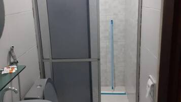 A compact bathroom with a toilet, sink, and shower area.