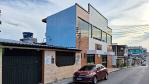 Un edificio moderno de dos pisos con fachada azul y ventanas amplias.