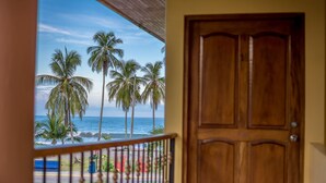 A wooden door and a balcony railing. - Hotel Manuel Antonio (Quepos)