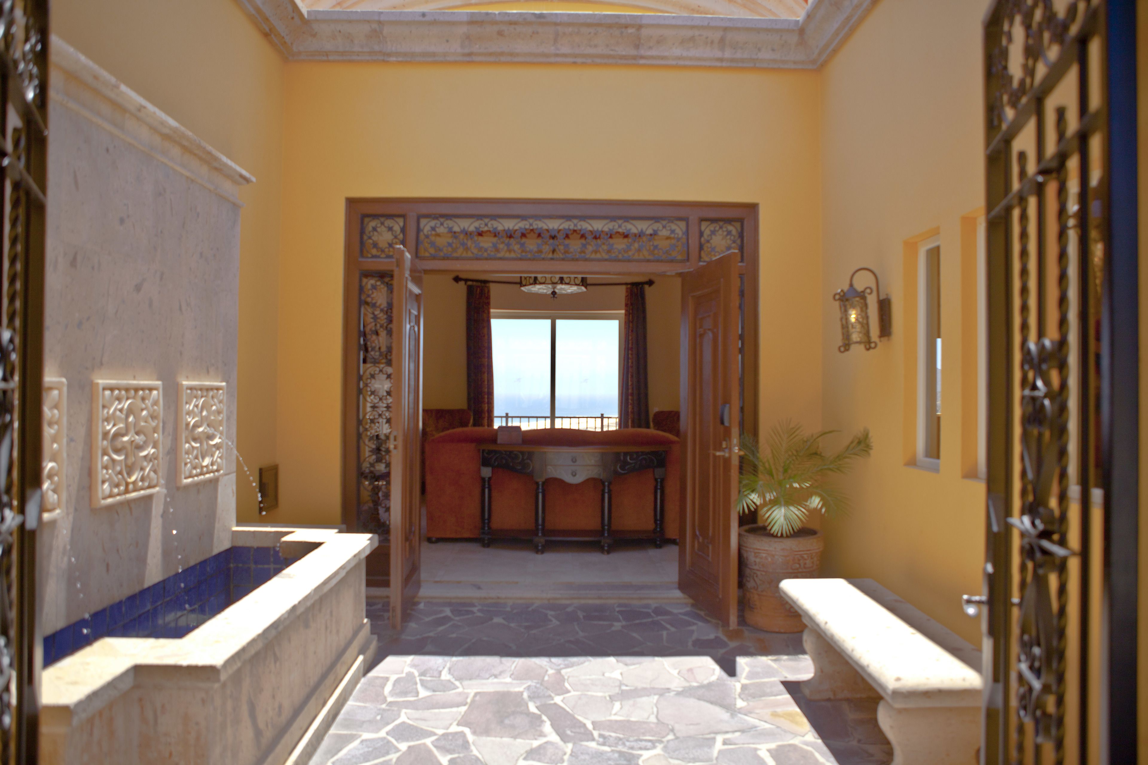 A luxurious bathroom with a bathtub, a bench, and a potted plant.