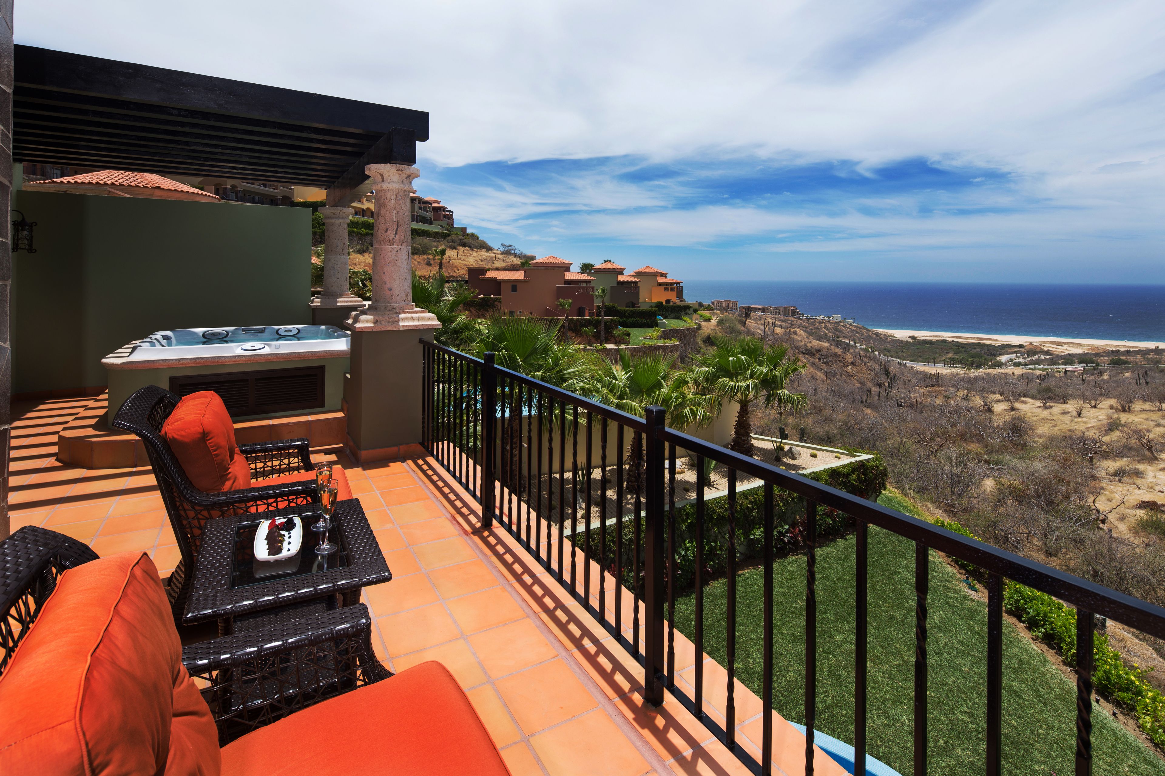 Ein Balkon mit Sitzgelegenheit im Freien, einem Whirlpool und Blick aufs Meer.