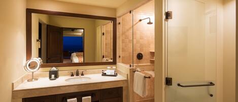 A bathroom with a large mirror, two sinks, a shower, and a glass door.