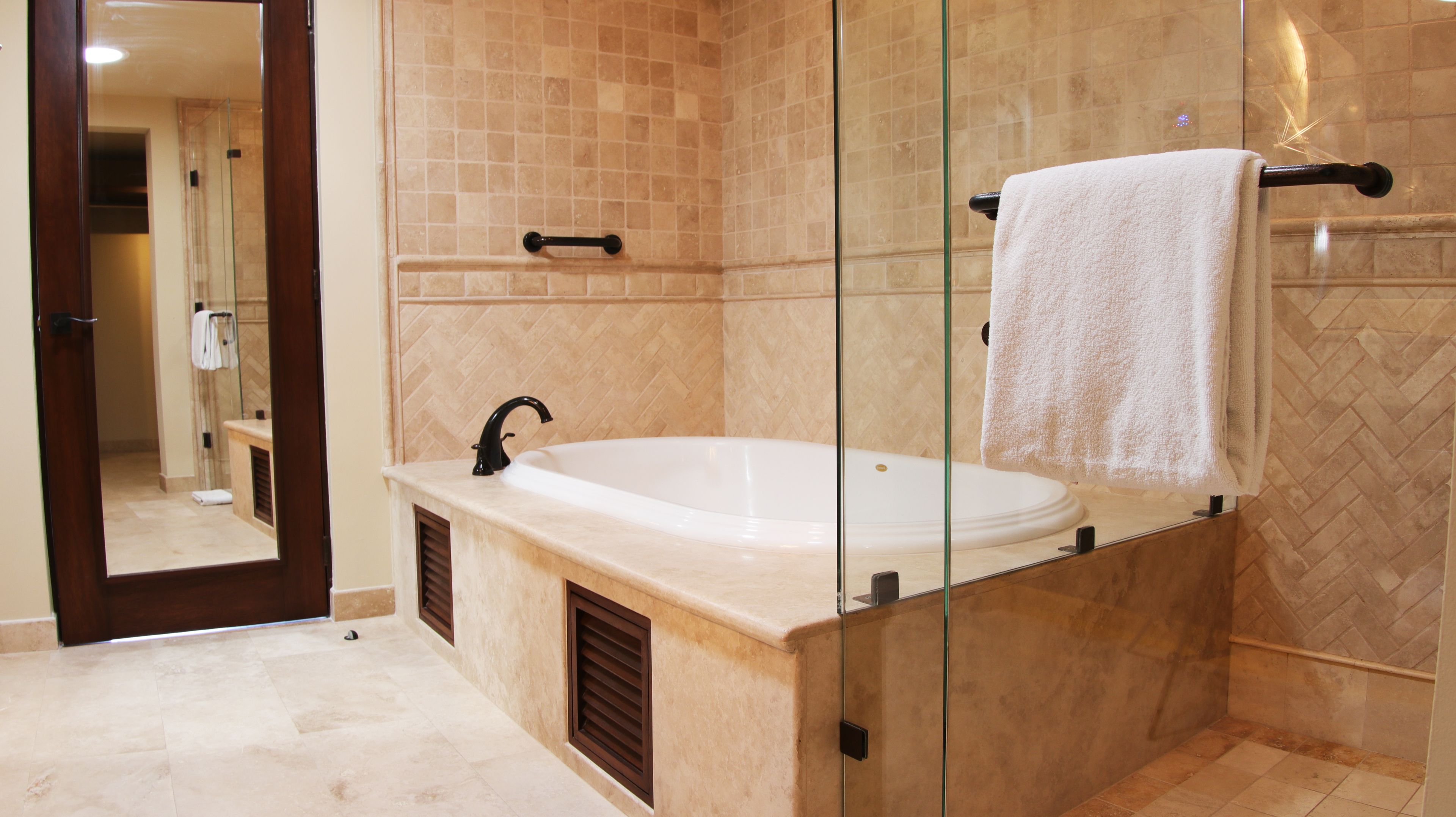 Ein modernes Badezimmer mit einer freistehenden Badewanne, einer Duschkabine aus Glas und einem Handtuchhalter.