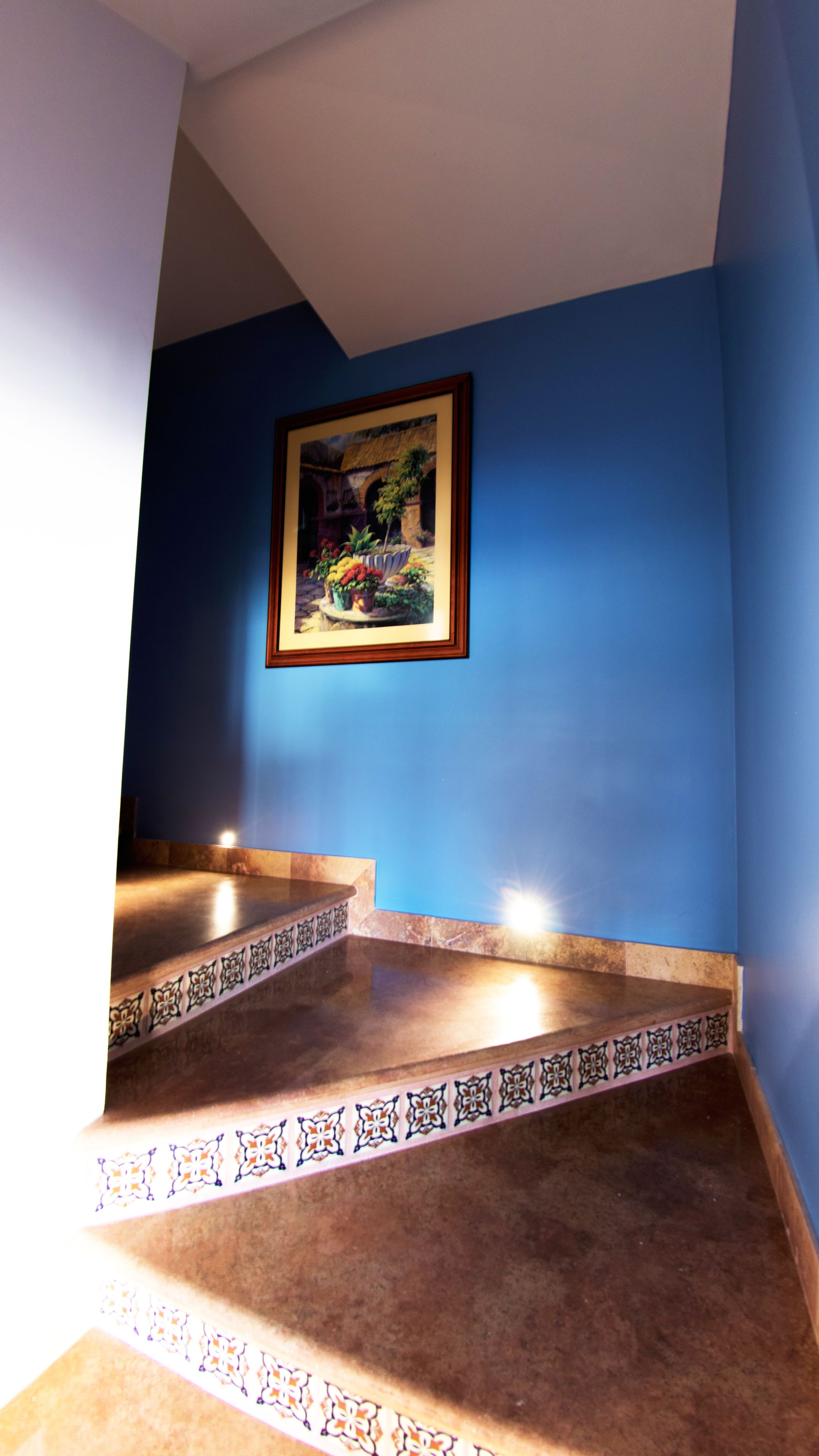 Eine Treppe mit blauer Wand und einem Bild darüber.