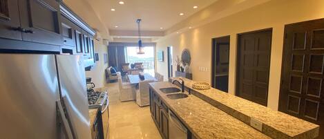 A modern kitchen with granite countertops, stainless steel appliances, and a central island.