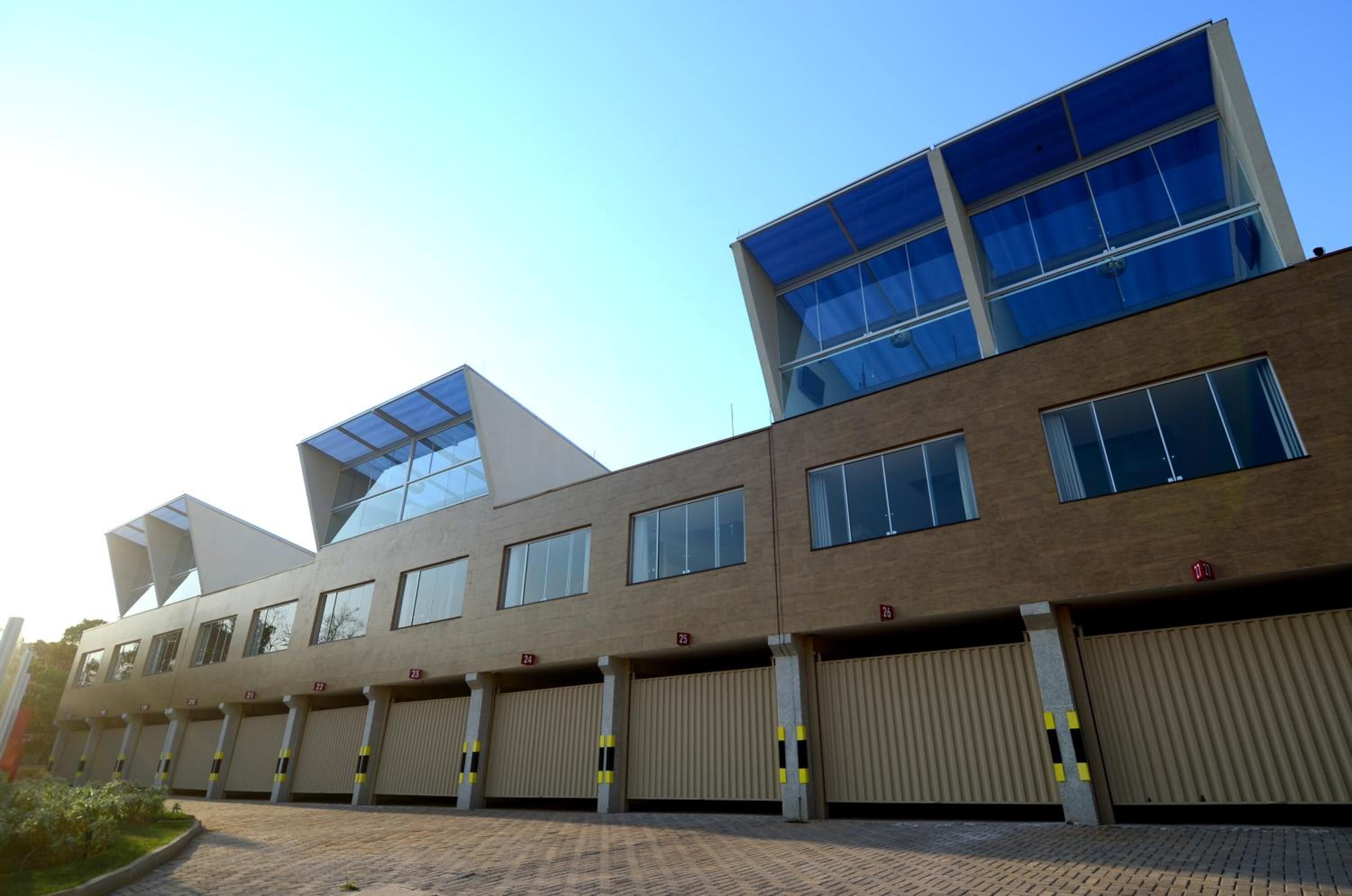 A modern building with multiple floors, large windows, and a brick facade.